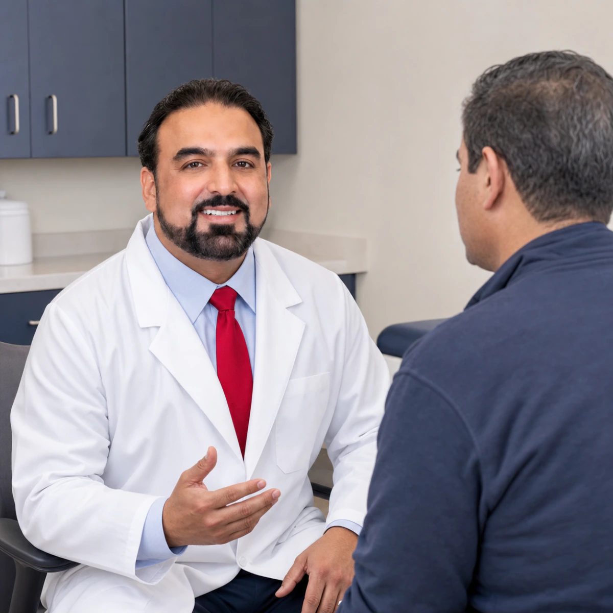 Dr. Pramjeet Ahluwalia listening to a male patient during a primary care visit